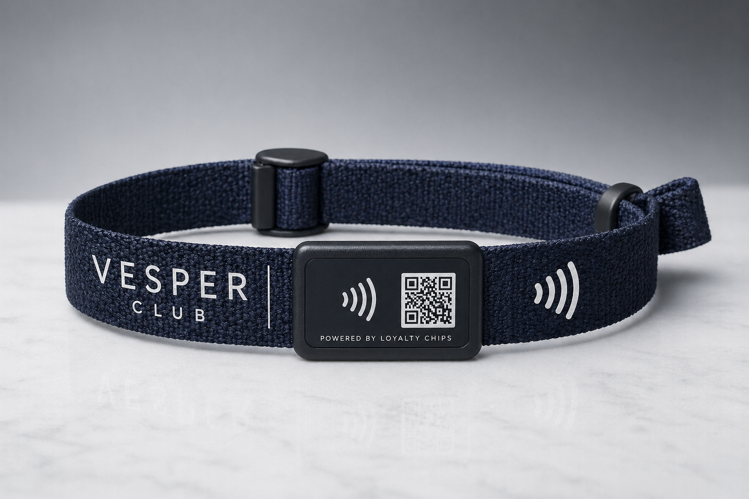 Vesper Club navy woven wristband with a plastic snap closure, NFC module, and QR patch.